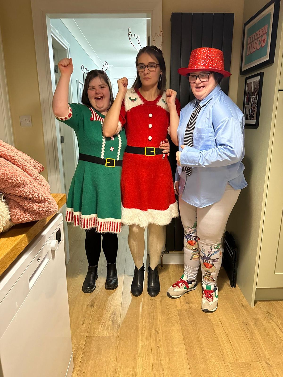 Three people dressed in Christmas outfits